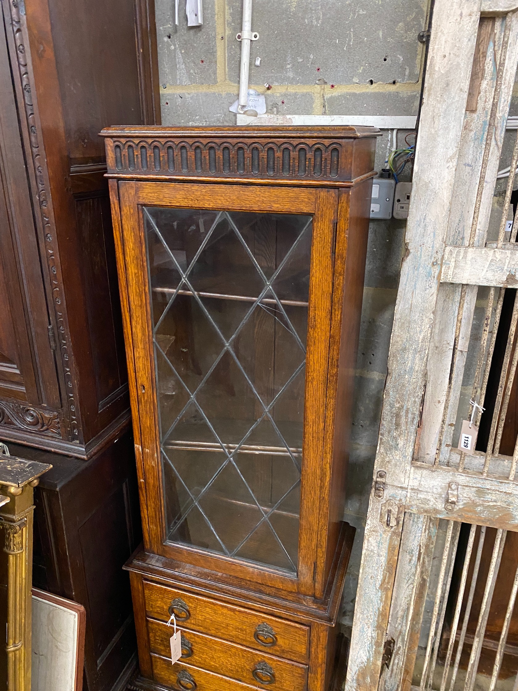 A 1920's narrow oak leaded glazed bookcase, width 52cm, depth 32cm, height 151cm